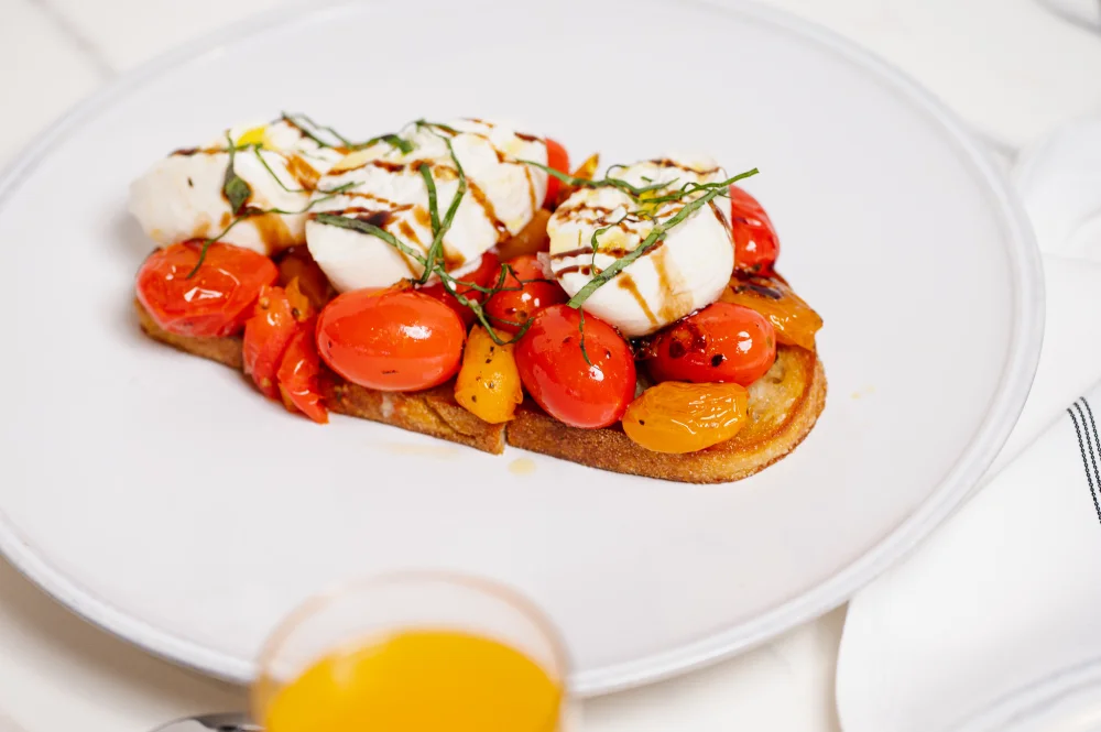 toasted bread topped with mozzarella, roasted cherry tomatoes, and balsamic drizzle