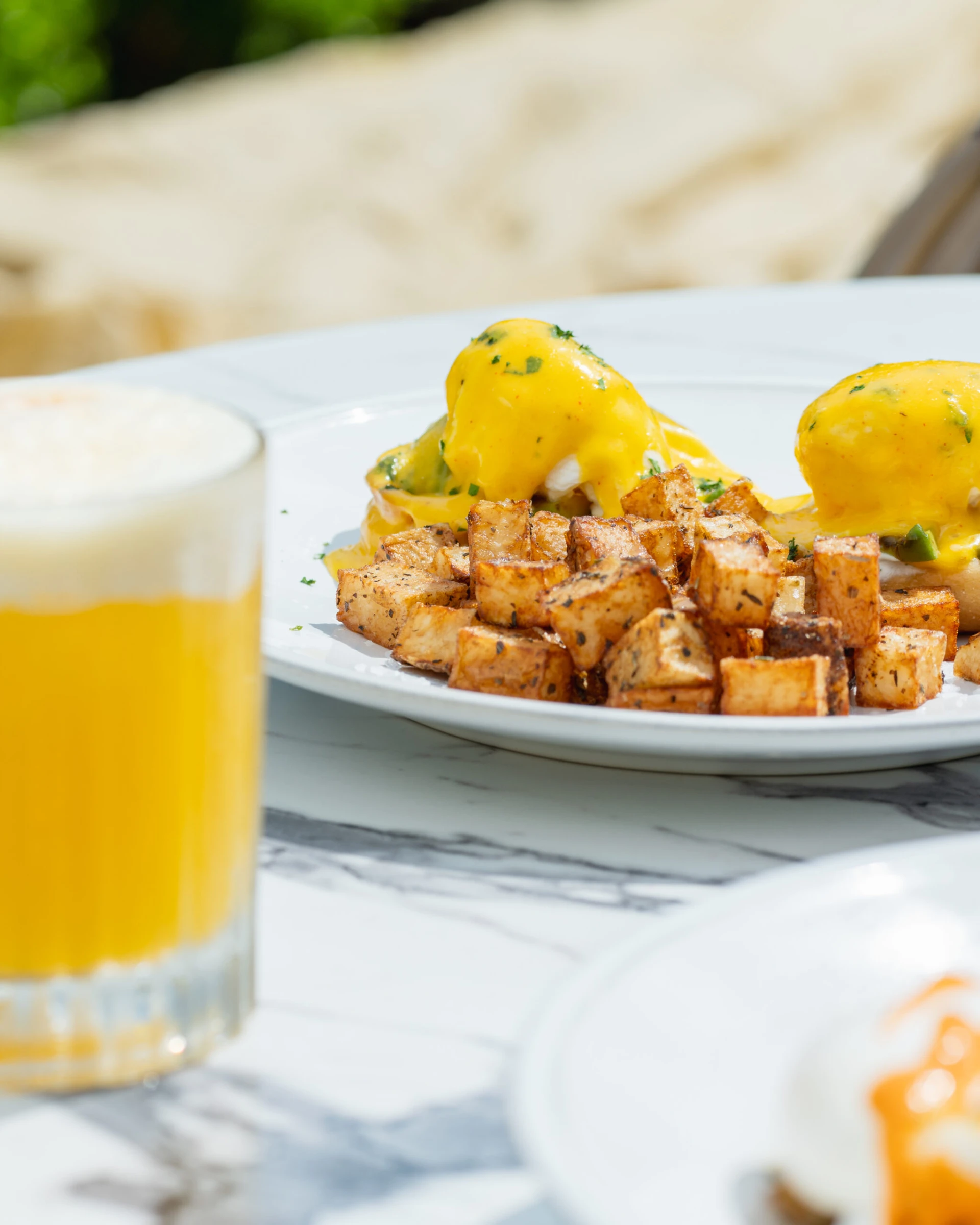 eggs benedict with golden hollandaise sauce and crispy breakfast potatoes
